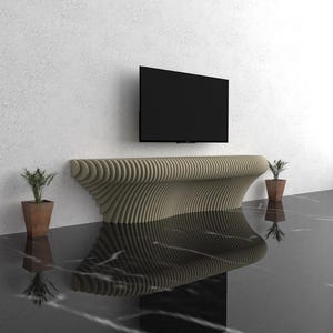 May include: A modern, wavy, beige wood TV stand with a black TV mounted on the wall above it. Two potted plants are on the floor, one on each side of the stand.