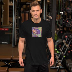 Pode incluir: Camiseta preta com um gráfico de cérebro colorido. A ilustração do cérebro usa tons de roxo, laranja e amarelo, em um fundo multicolorido. A camiseta é de estilo gola redonda clássica.