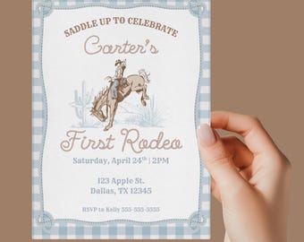 May include: A rodeo-themed invitation with a light blue gingham border and rope-style accents. The invitation features the text "Saddle Up to Celebrate Carter's First Rodeo" with a graphic of a cowboy riding a bucking bronco. Includes event details.