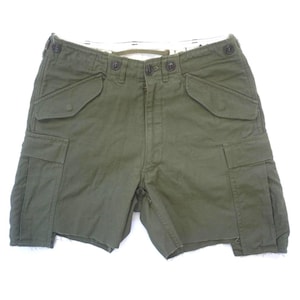 May include: Olive green cargo shorts with multiple pockets and button closures. The shorts have a relaxed fit and a raw hemline. The shorts are made of a durable fabric, suitable for outdoor activities.