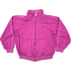 May include: A vintage pink zip-up sweatshirt with a small embroidered Nike logo on the left chest.