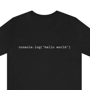 May include: Black t-shirt with the text "console.log('hello world')" printed in white. The shirt is a basic crew neck style, suitable for casual wear. The text is in a monospace font, common in coding.