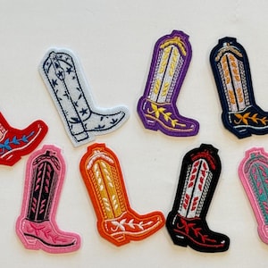 May include: Eight embroidered iron-on patches of cowboy boots in various colors and designs. The boots are all in a classic style with a pointed toe and a high heel.