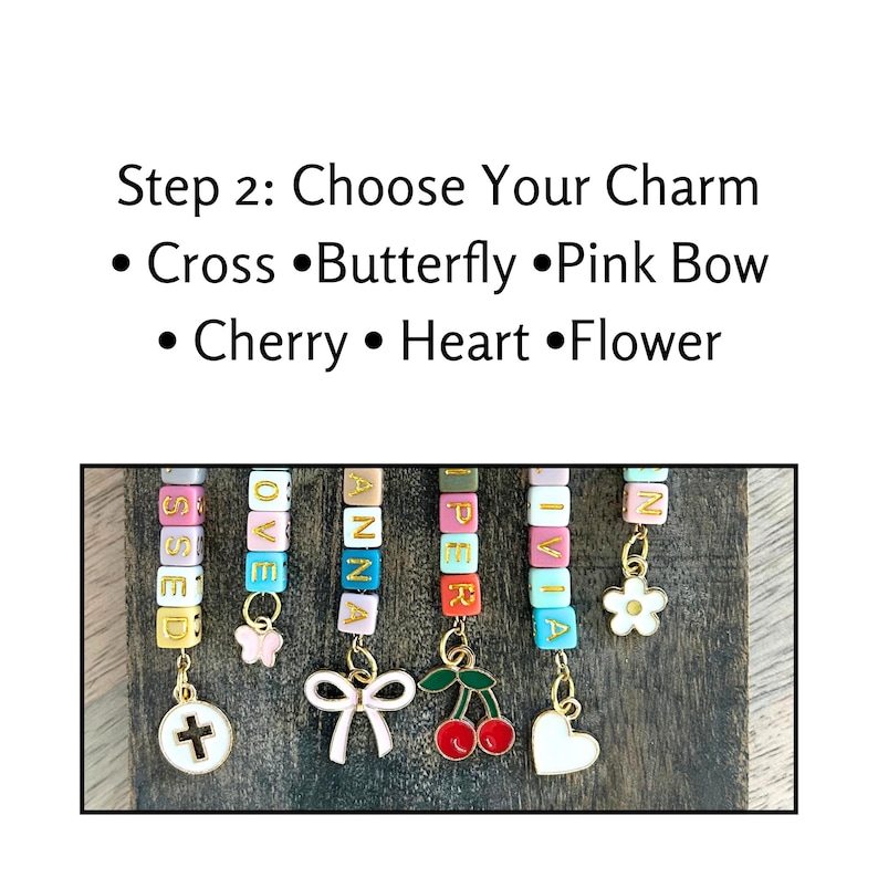 May include: A wooden display of personalised charm bracelets. Each bracelet features colourful letter beads spelling out names, with charms including a cross, butterfly, bow, cherries, heart, and flower. The text "Step 2: Choose Your Charm" is above the bracelets.