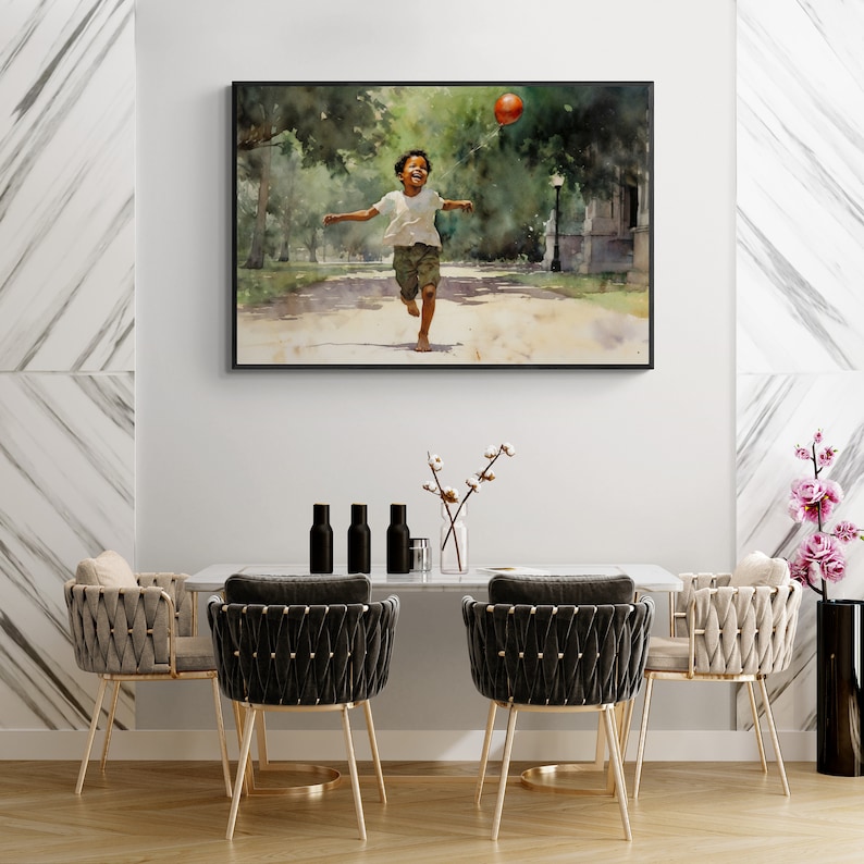 May include: A watercolor painting of a young boy running through a park with a red ball in the air. The painting is framed in a black frame and is hanging on a white wall.