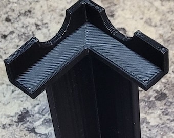 May include: A black 3D printed stand with three arms that form a triangular shape. The stand has a round base.