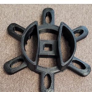 May include: Black plastic tool with six arms and a square hole in the center. The tool is designed to remove panels on a Jeep Freedom.