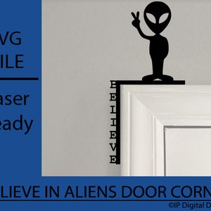 Puede incluir: Silueta negra de un extraterrestre sosteniendo un signo de paz, de pie en un marco de puerta blanco con la palabra "BELIEVE" escrita verticalmente en el marco. El texto "BELIEVE IN ALIENS DOOR CORNER" está escrito debajo del marco de la puerta.