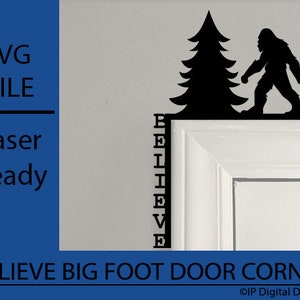 Op de afbeelding: Zwarte silhouet van Bigfoot en een dennenboom met het woord "BELIEVE" verticaal geschreven aan de linkerkant. Het silhouet is bevestigd aan een wit deurkozijn.