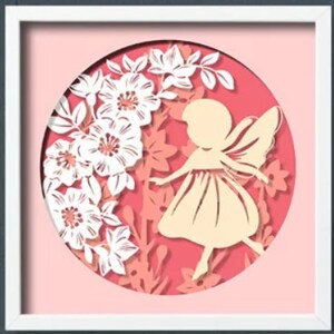 Puede incluir: Un hada de papel con alas, vestida con un vestido, rodeada de flores blancas en un círculo rosa.