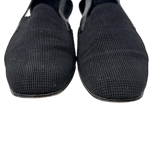 May include: A pair of black slip-on shoes with a textured fabric upper.
