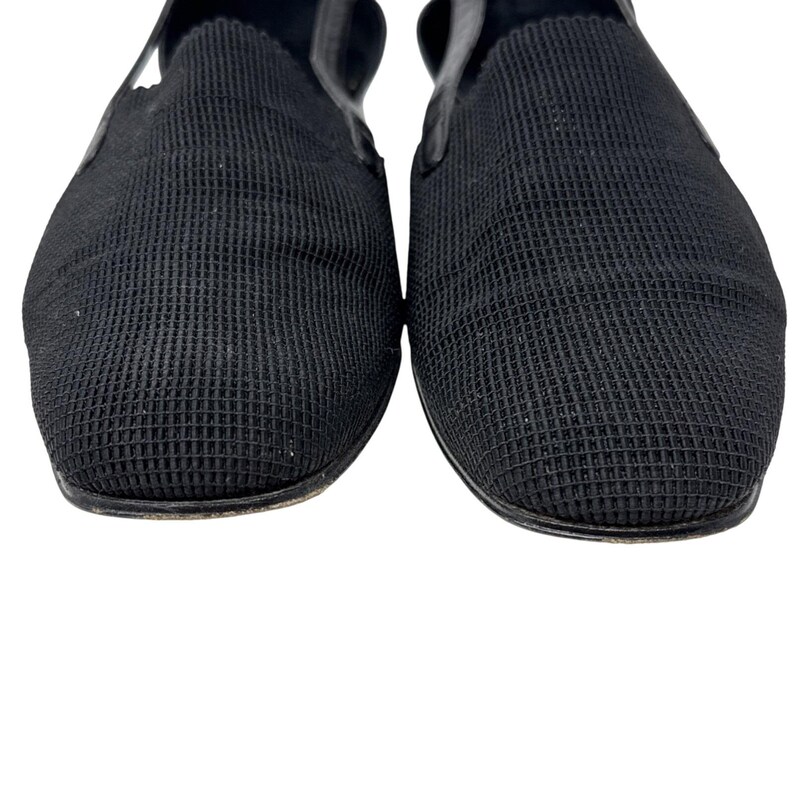 May include: A pair of black slip-on shoes with a textured fabric upper.