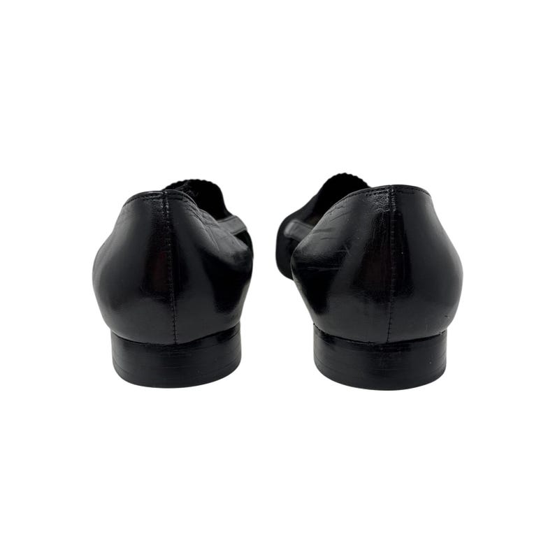 May include: A pair of black leather ballet flats with a pointed toe.