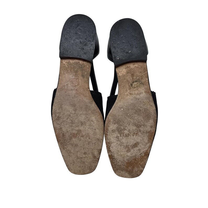 May include: A pair of black leather sandals with a criss-cross strap design. The sandals have a flat sole and a pointed toe.