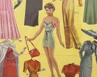 May include: A vintage paper doll set featuring a woman with red hair and a variety of outfits, including a dress, trousers, and a top. The paper doll is set against a yellow background.