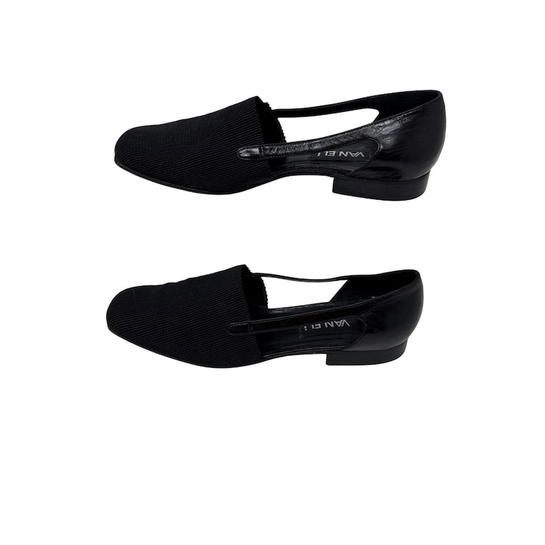 May include: A pair of black leather flats with a cut-out design and the text "VANELI" on the side.