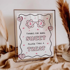 Könnte beinhalten: Ein rosa-weißes Schild mit dem Text "Danke, dass du so süß bist, nimm dir einen Leckerbissen". Das Schild hat ein rosa Herz mit dem Text "cutie pie" und ein rosa Herz mit dem Text "rule breaker". Außerdem sind rosa Herzen mit Lippen und Sternen auf dem Schild.