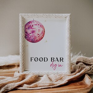 May include: White framed sign with a pink disco ball illustration and the text "FOOD BAR dig in" in black and pink lettering.