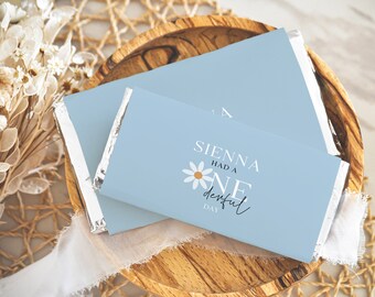 Op de afbeelding: Een lichtblauwe chocoladeverpakking met een witte madeliefje en de tekst "Sienna had a one derful day".