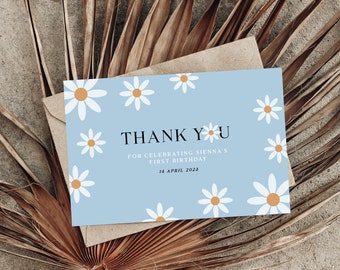 May include: A light blue thank you card with white daisies and a yellow center. The card says "Thank You" for celebrating Sienna's first birthday, 14 April 2023.