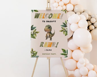 Op de afbeelding: Welkom bij Brody's Rawr! Een verjaardagsfeestje. Een welkomstbord met een cartoon-dinosaurus, groene bladeren en de tekst "Welkom bij Brody's Rawr! Een verjaardagsfeestje."
