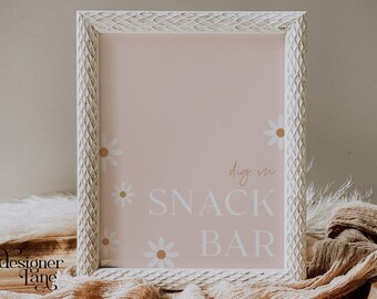 May include: A white framed sign with a pink background and white daisies. The sign says "dig in SNACK BAR" in white text.