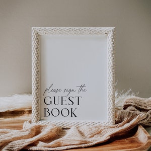 May include: White wooden frame with a white mount and the text "Please sign the GUEST BOOK" in black calligraphy.