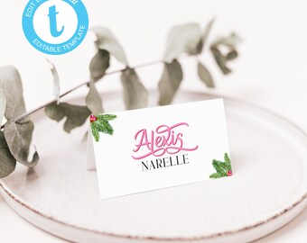 May include: White place card with a pink cursive name "Alexis NARELLE" and green pine branches with red berries on each side.