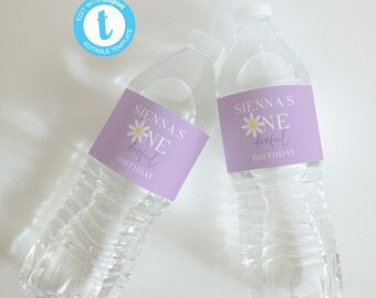 May include: Two clear plastic water bottles with purple labels that say "Sienna's One Derful Birthday" with a white daisy graphic.