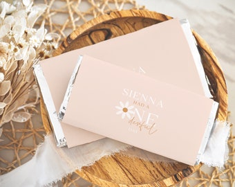May include: A pink and white chocolate bar wrapper with a daisy design and the text "Sienna had a one derful day".