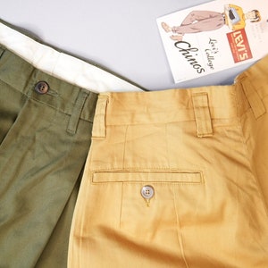 Op de afbeelding: Twee paar Levi's chino's, een in olijfgroen en een in mosterdgeel. Beide paren hebben een knoopsluiting en een achterzak met een knoop.