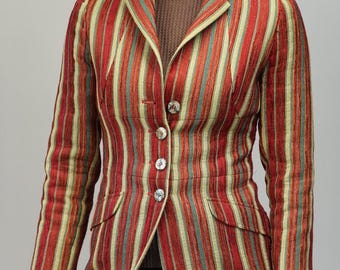 May include: A long, tailored coat with vertical stripes in red, yellow, and teal. The coat features a notched collar, three decorative buttons, and two front pockets. The coat is worn over a brown top and black pants.