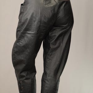 May include: Black leather pants with a high waist and lace-up detailing at the ankles.