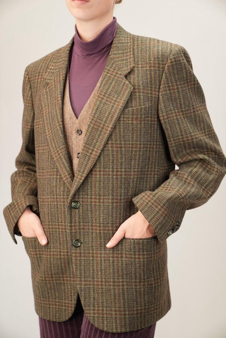 以下が含まれることがあります： 茶色と緑のチェック柄ブレザー、お揃いのベスト、紫のタートルネック。 ブレザーにはフロントポケットが2つ、袖口にはボタンが3つ付いています。 ベストはボタン留めです。 この服装はクラシックなスタイルです。