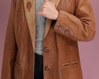May include: A brown leather jacket with a button-up front and a contrasting tan collar. The jacket has a distressed look and features decorative buttons.