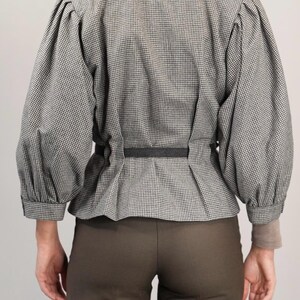 May include: A black and white gingham blouse with a cinched waist and puffed sleeves.