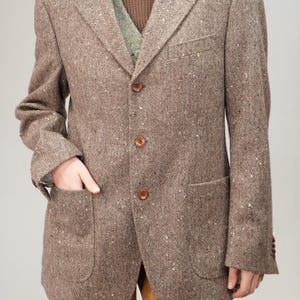 May include: A brown tweed blazer with a three-button fastening and two flap pockets.