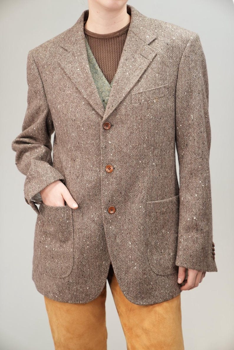 May include: A brown tweed blazer with a three-button fastening and two flap pockets.