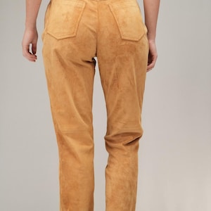 May include: A pair of brown suede pants with a high waist and a straight leg.