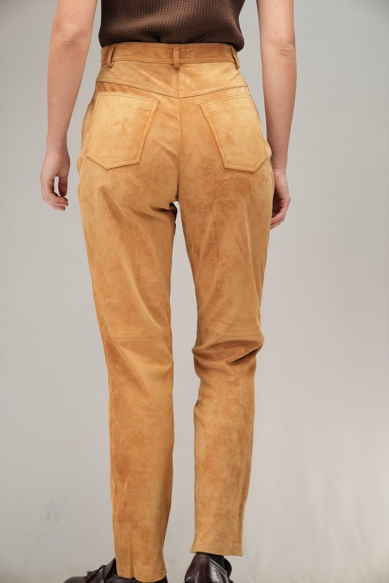 May include: A pair of brown suede pants with a high waist and a straight leg.