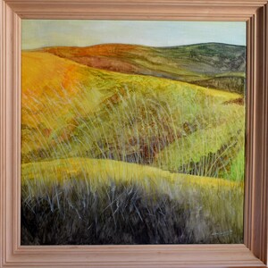 Può includere: Dipinto di paesaggio incorniciato raffigurante dolci colline nei toni del giallo, verde e marrone. Alte erbe sottili ondeggiano in primo piano. L'opera è racchiusa in una cornice di legno chiaro.
