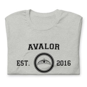 Könnte beinhalten: Graues T-Shirt mit schwarzem Text, der "AVALOR EST. 2016" lautet, und einem schwarzen Kreis mit einer Krone darin.