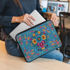 May include: A blue laptop sleeve with a colorful floral and hummingbird design. The sleeve has a zipper closure and is made of a durable material.