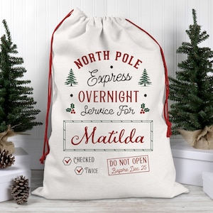 May include: A white Christmas gift sack with a red drawstring. The sack is printed with "North Pole Express Overnight Service For Matilda" in red and green. Includes a "Checked Twice" stamp and "Do Not Open Before Dec 25" stamp.