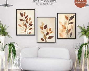 Peut inclure: Trois impressions d'art botanique encadrées avec des feuilles marron et beige sur un fond clair. Les cadres sont noirs. Le texte "MIRAY'S COLORS Curated Boho Art" est au-dessus des impressions. Un bouton de téléchargement numérique est en haut à droite.