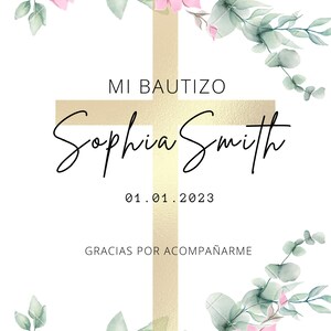 May include: A white card with a gold cross and pink flowers. The text "MI BAUTIZO Sophia Smith 01.01.2023 GRACIAS POR ACOMPA&Ntilde;ARME" is printed on the card.