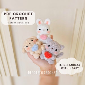 May include: Crochet pattern for a 3-in-1 animal with heart. The pattern includes a bunny, a dog, and a cat, each holding a heart. The animals are crocheted in white, beige, and gray yarn. The pattern is available for instant download.  "DEPOTETO.CROCHET"