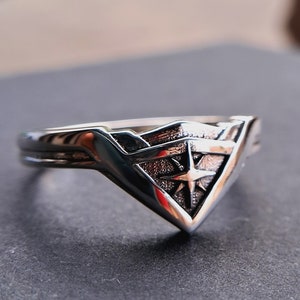 Pu&ograve; includere: Un anello d'argento con un design a logo di Wonder Woman. Il logo &egrave; una 'W' stilizzata con una stella al centro.