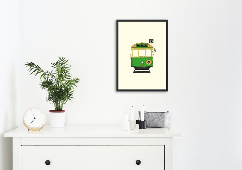 May include: A framed illustration of a green and yellow tram with the number 35 and the words "City Circle" on the front.