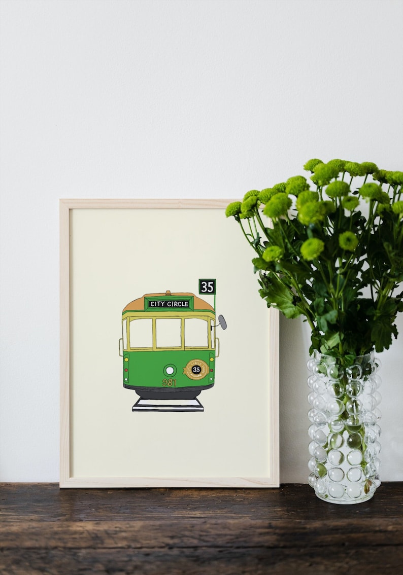May include: A framed print of a green and yellow tram with the words "City Circle" and the number "35" on it. The tram is on a cream background.